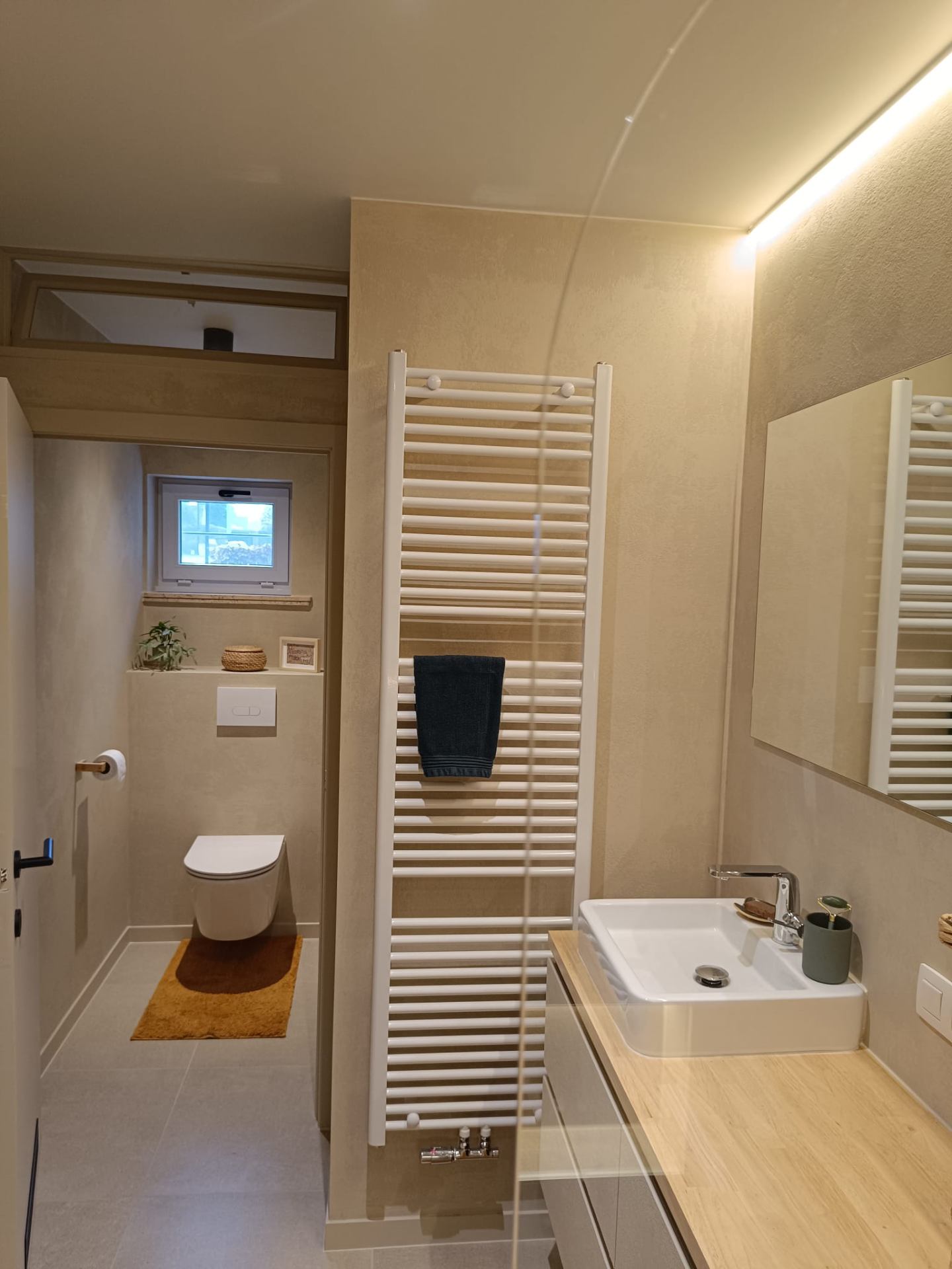 Ruime badkamer met leemstuc afwerking en sfeerverlichting