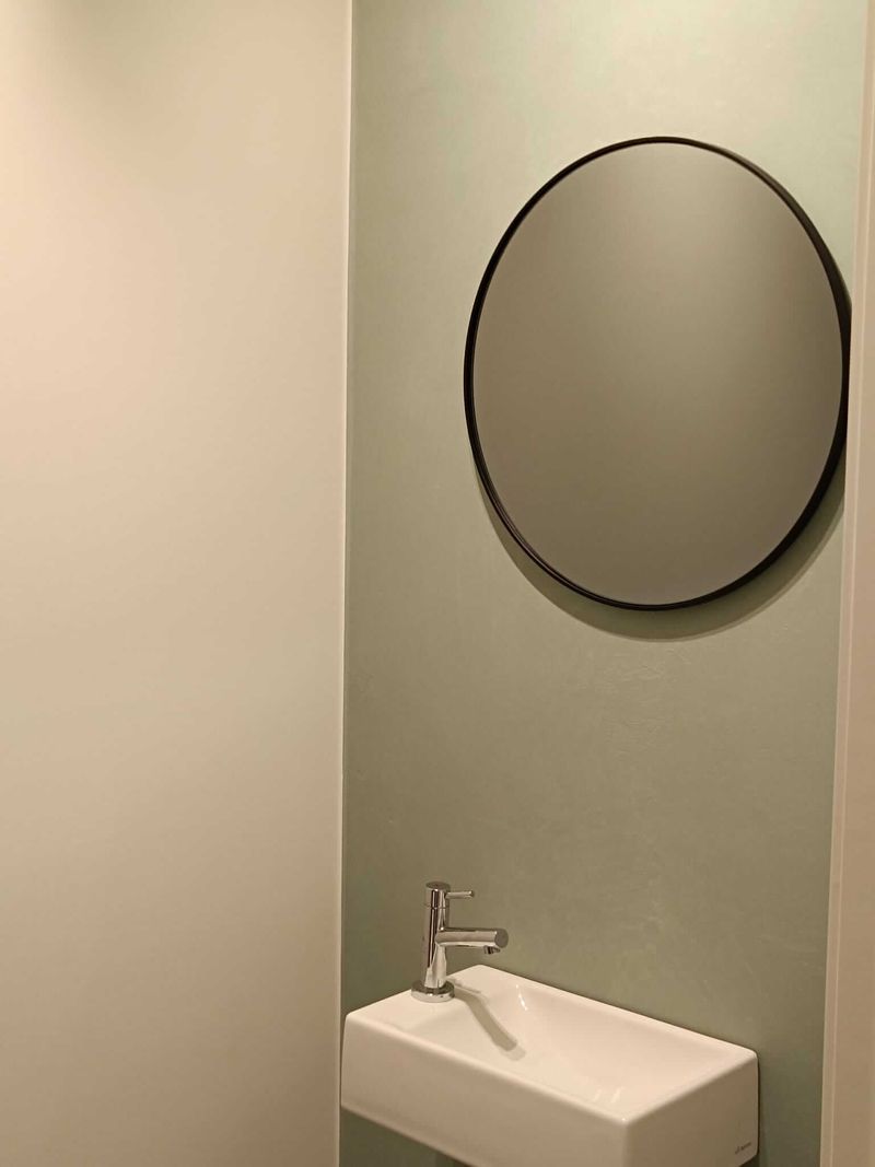 Badkamer met mintgroene accentwand en spiegel
