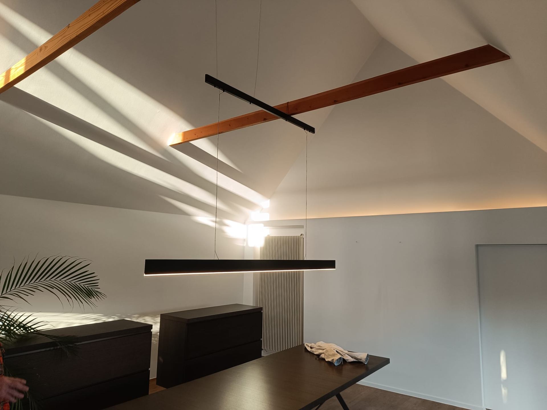 Moderne eetkamer met houten plafondbalken en designverlichting