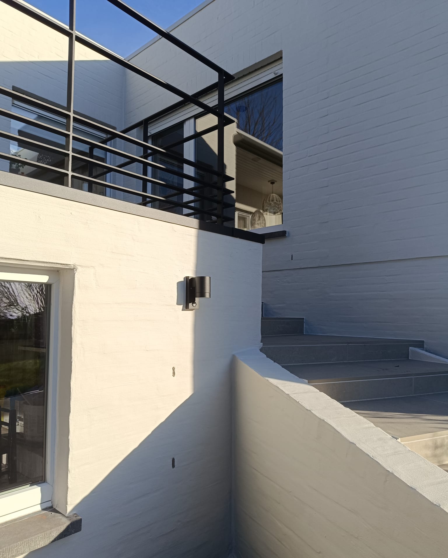 Moderne witte gevel met zwart balkonhekwerk