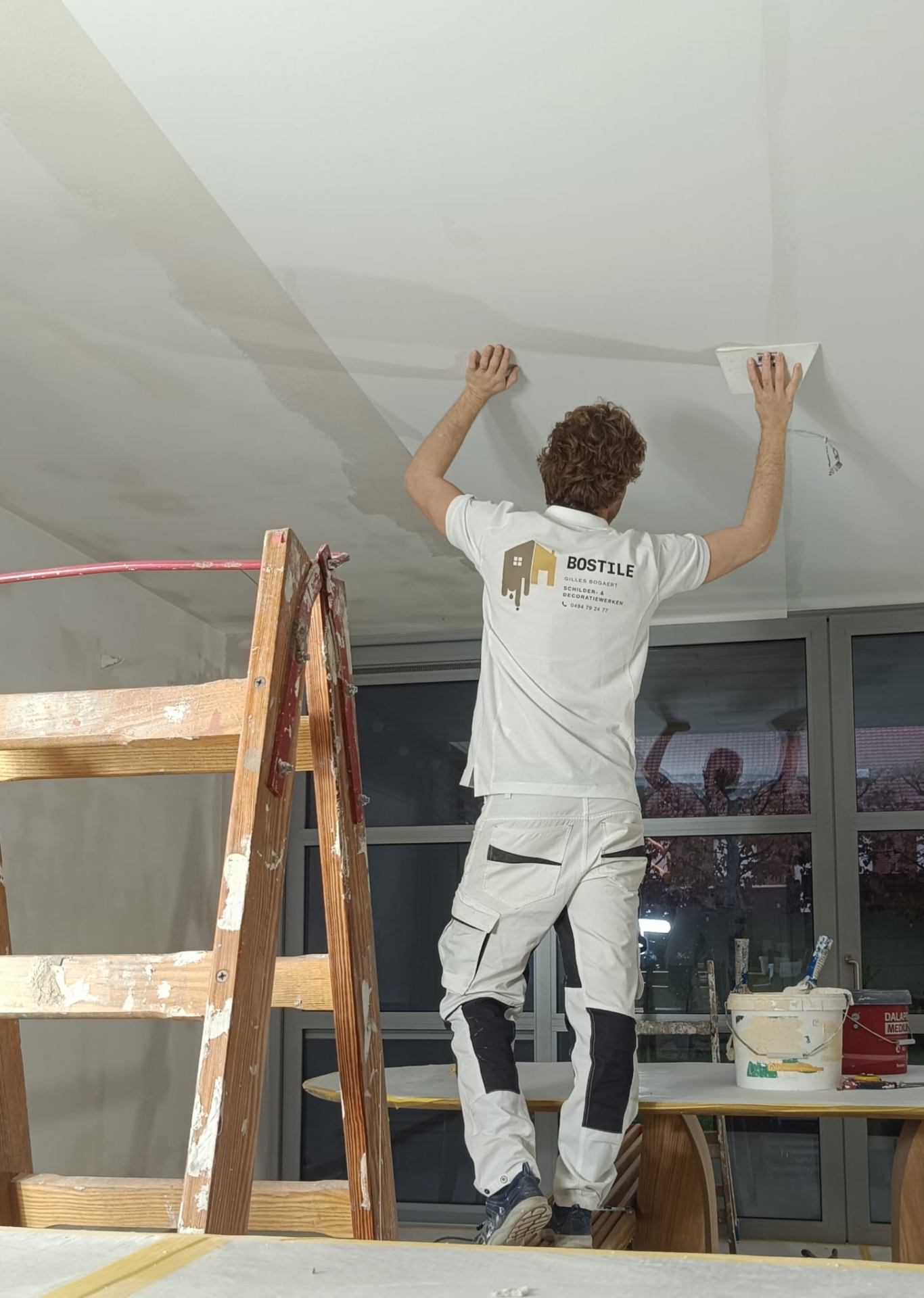 Vakman werkt aan plafondafwerking met precisie