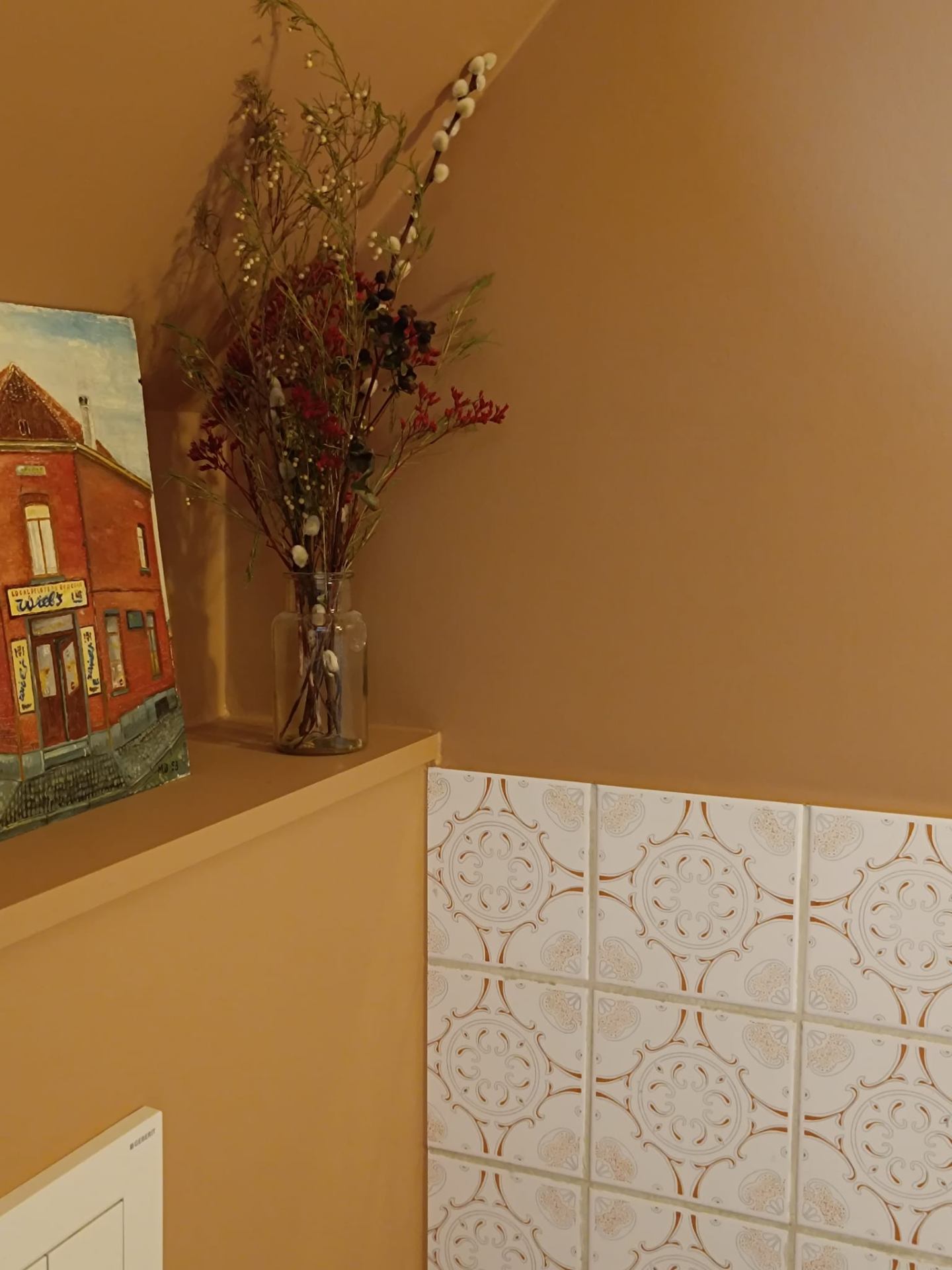 Toilet met okergele wand en decoratieve tegels