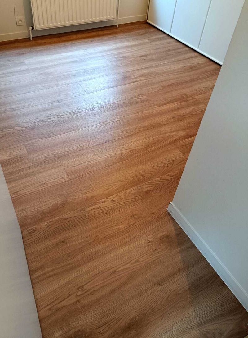Vloer met houten afwerking en witte plinten